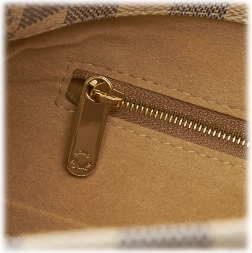 The Artsy MM features a damier azur canvas body, a rolled vachetta handle, an open top, and interior zip and slip pockets. - Avvenice